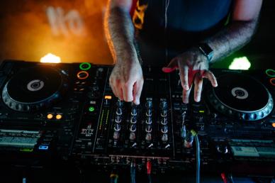 DJ adjusting the sound board of his equipment