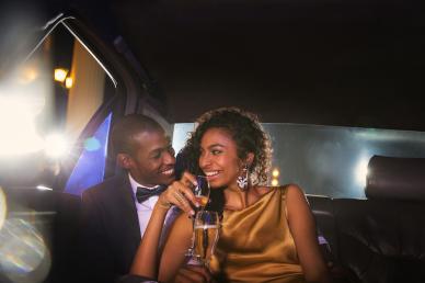 Couple sitting in a limousine as part of their date night, a glass of champagne in the woman's hand
