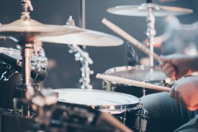 Drum set with musician sitting playing the drums