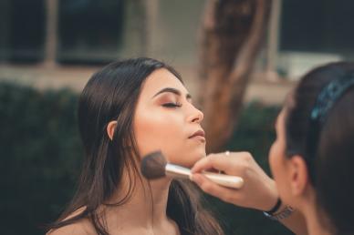 Makeup Artist applying bronzer with a brush to a client
