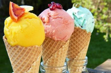 Three colorful scoops of ice cream in waffle cones