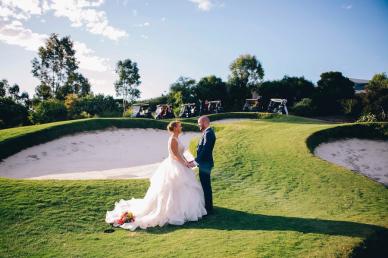 Bride and groom on a golf course, posing for wedding photos