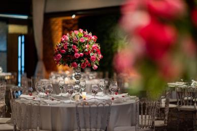 Round tables with large floral centerpieces and white table cloth with place settings