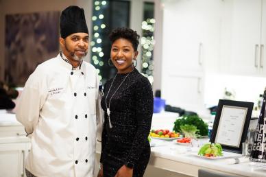 Chef and assistant standing next to each other smiling