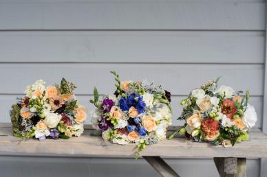 Three bouquets of flowers laying on a table