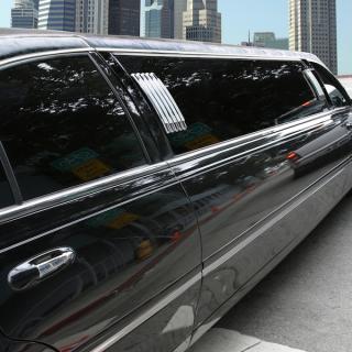 Black limousine, side view starting from rear door to looking to the front end of the limo