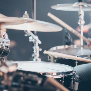 Drum set with musician sitting playing the drums