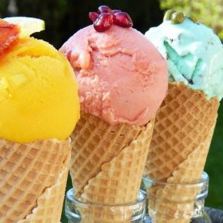 Three colorful scoops of ice cream in waffle cones