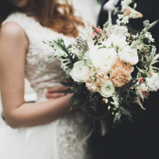 Bride and groom with flower arrangement in the bride's hand