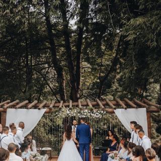 Wide view of an outdoor wedding ceremony with the couple, wedding party, and guests in view