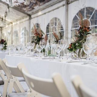 Wedding decor of the reception with tables and chairs inside a tent