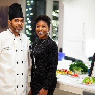 Chef and assistant standing next to each other smiling