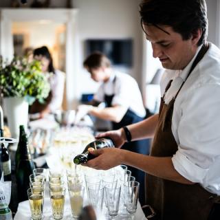 Serving staff pouring a glass of champagne