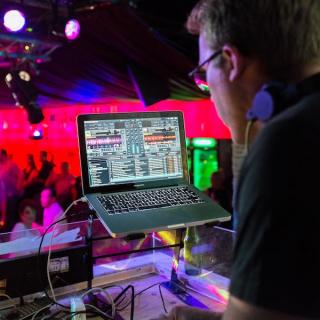 DJ set up with a party in the background