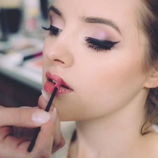 Makeup artist applying lipstick to client