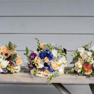 Three bouquets of flowers laying on a table