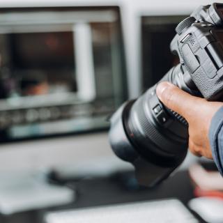 Photographer looking at images on his camera while sitting at his computer